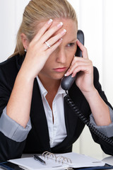 frustrierte Frau mit Telefon im Büro