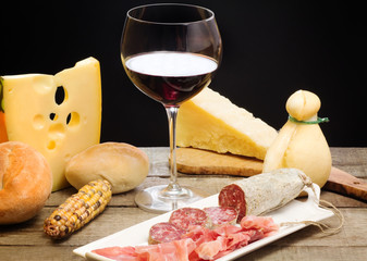 selection of cheese and ham with glass of red wine