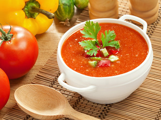 Gazpacho and ingredients on a table, vegetable soup