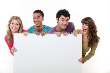 group of friends holding a blank poster