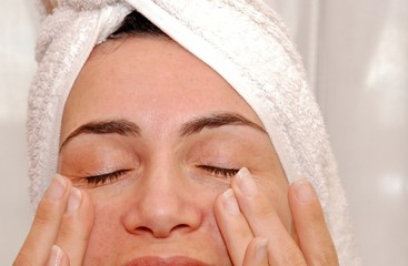 donna che applica crema sul viso