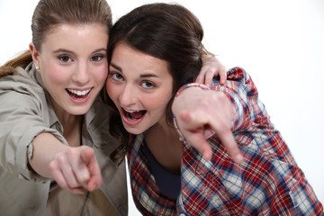 Two friends pointing at the camera.
