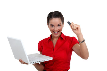 Happy woman with a USB key and laptop