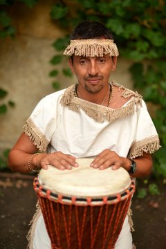 Portrait of young latino percusionist playing african drums