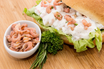 Roll with Shrimp-Salad on a cutting board