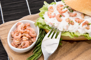 Roll with Shrimp-Salad on a cutting board