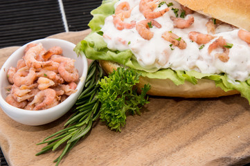 Roll with Shrimp-Salad on a cutting board