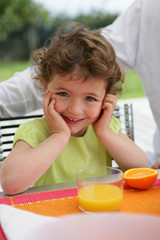 Child drinking a class of freshly squeezed orange juice