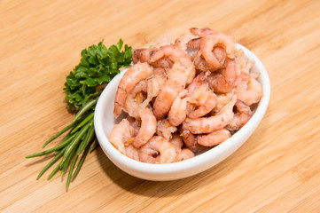 Small bowl with Shrimps on wooden background