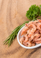Small bowl with Shrimps on wooden background