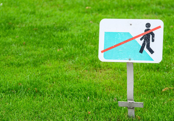 Fresh green grass and sign " No walking on grass"