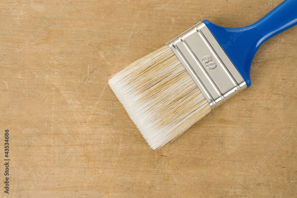 Sticker colorful paintbrush on wood background