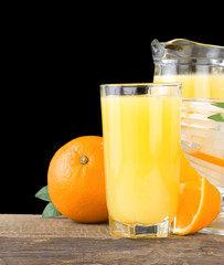 orange fresh fruits and juice in glass isolated on black