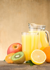 fresh fruits juice in glass and slices on wood