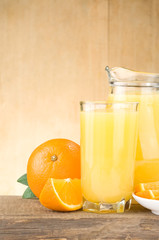 fresh fruits juice in glass and slices on wood