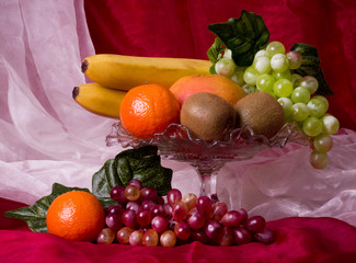 Beautiful composition with fruits on vase on red background