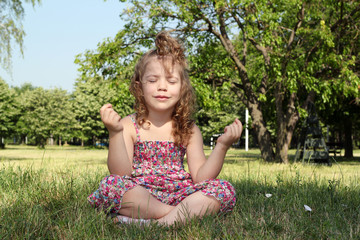 little girl meditates in nature