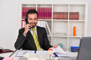Junger Geschäftsmann im Büro telefoniert