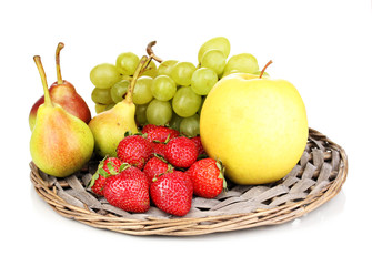 ripe sweet fruits and berries on wicker mat isolated on white