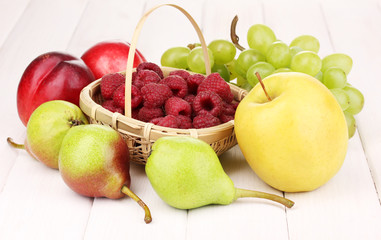 ripe sweet fruits and berries on wooden background