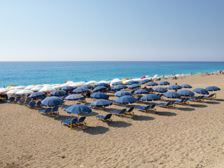 Fototapeta na wymiar Beach Umbrellas on Sand by Water