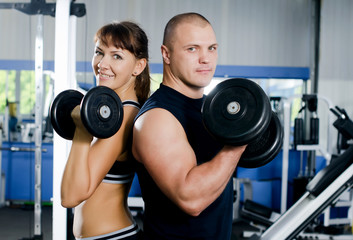 The woman with the trainer in sports club