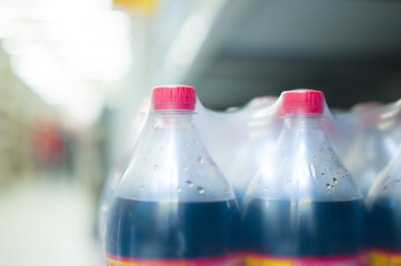 Bottles with soda drinks in supermarket