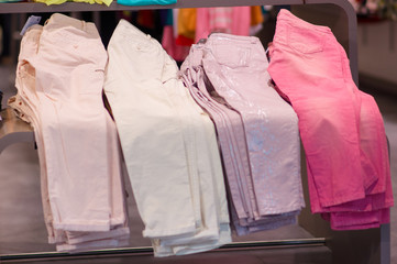 Variety of color jeanses on table in mall