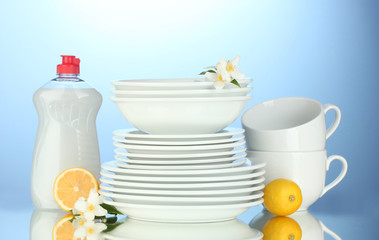 empty clean plates and cups with dishwashing liquid and lemon