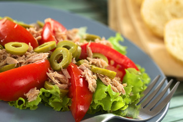 Fresh tuna, tomato and green olive salad on lettuce leaf