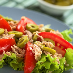 Fresh tuna, tomato and green olive salad on lettuce leaf