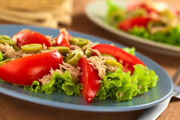 Fresh tuna, tomato and green olive salad on lettuce leaf
