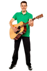 Young caucasian guitarist playing tracks