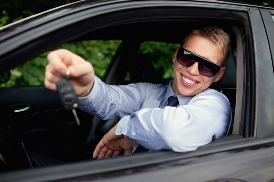 Young man  buying new car, smiling