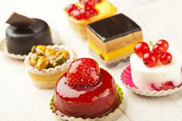 Different sort of beautiful pastry, small colorful sweet cakes
