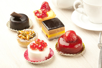 Different sort of beautiful pastry, small colorful sweet cakes