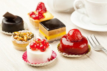 Different sort of beautiful pastry, small colorful sweet cakes