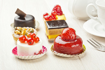 Different sort of beautiful pastry, small colorful sweet cakes