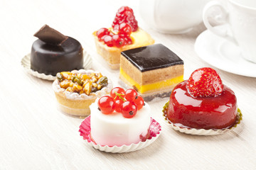 Different sort of beautiful pastry, small colorful sweet cakes