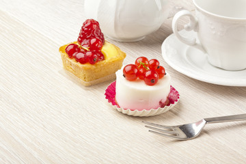 fruit pastry little cake with tea cup on white wooden table