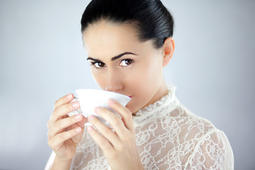 Pewna siebie kobieta pijąca aromatyczną herbatę z cukrem - obrazy, fototapety, plakaty