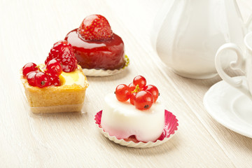 fruit pastry little cake with tea cup on white wooden table