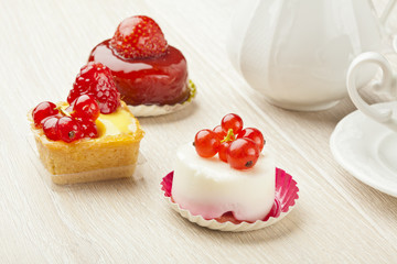 fruit pastry little cake with tea cup on white wooden table