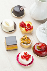 Different sort of beautiful pastry, small colorful sweet cakes