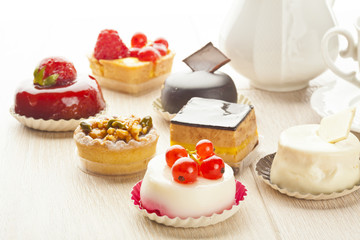 Different sort of beautiful pastry, small colorful sweet cakes