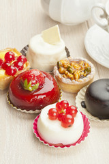 Different sort of beautiful pastry, small colorful sweet cakes