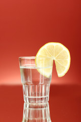 shot of tequila on red background close-up