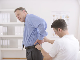 Obraz premium Physiotherapy: Physiotherapist examining senior man
