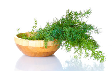 Dill in a wooden bowl isolated on white