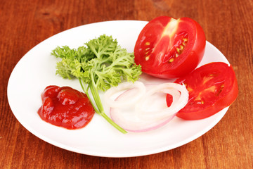 Ripe slices tomato on plate on wooden table